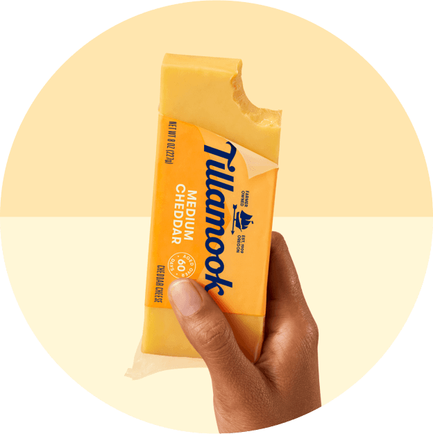 Hand holding Tillamook Medium Cheddar Block